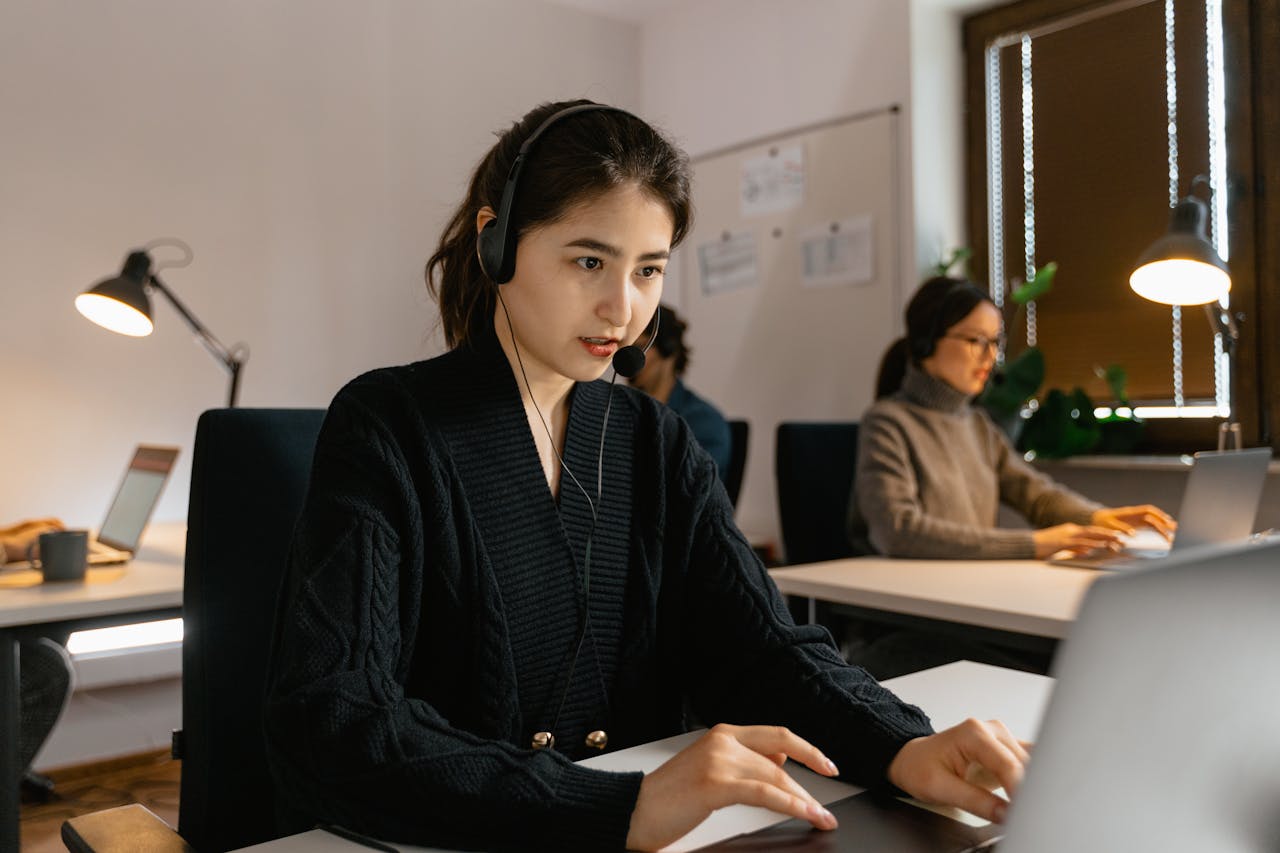 Crafting Captivating Headlines: Your awesome post title goes here Focused call center agents working with headsets in a modern office environment.